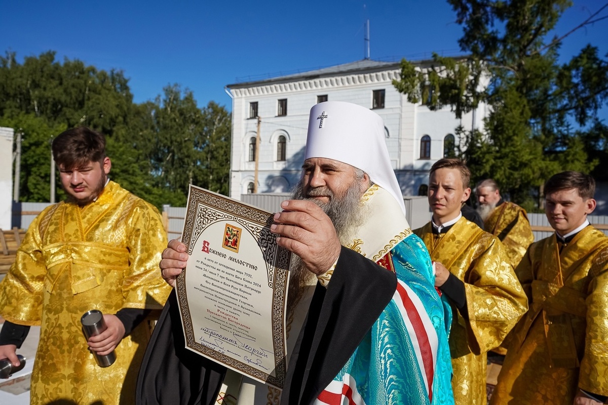 В руках митрополита Георгия памятное послание с именами причастных к строительству храма.