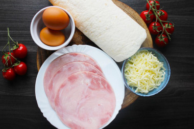 Как сделать треугольники из лаваша с ветчиной и сыром? Подготовьте все продукты, которые указаны в рецепте. Вместо ветчины можно использовать любую варёную или копчёную колбасу. Сыр хорошо подходит твёрдых сортов, но и с мягкой моцареллой выйдет очень интересно и вкусно