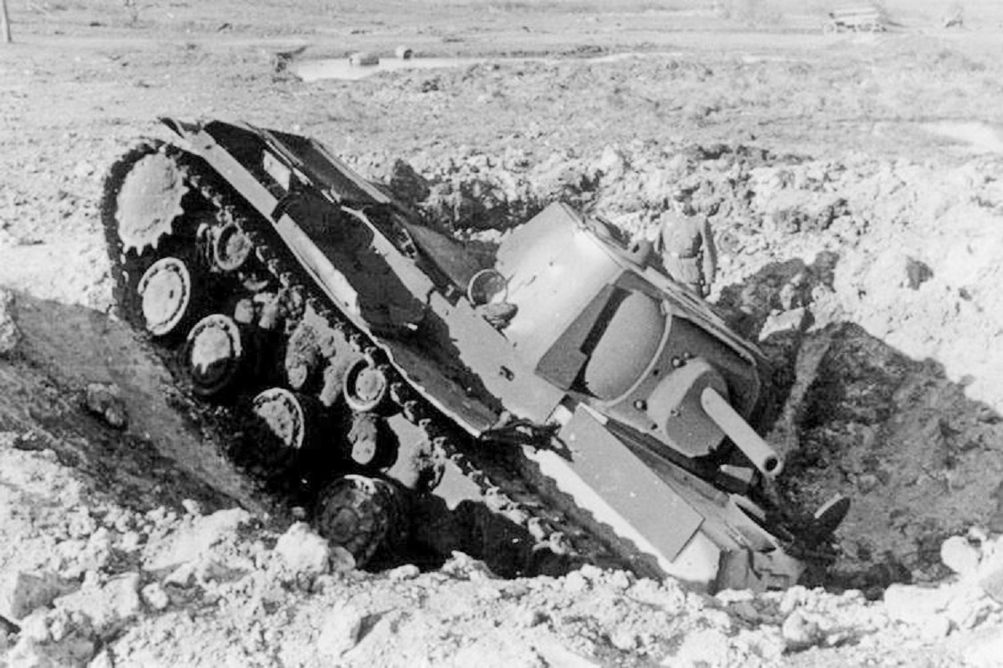 Германский офицер из 506-го пехотного полка 291-й пехотной дивизии фотографируется возле подбитого советского тяжелого танка КВ-1 из 2-го танкового полка. Ленинградская область, Агакули, октябрь 1941 года.