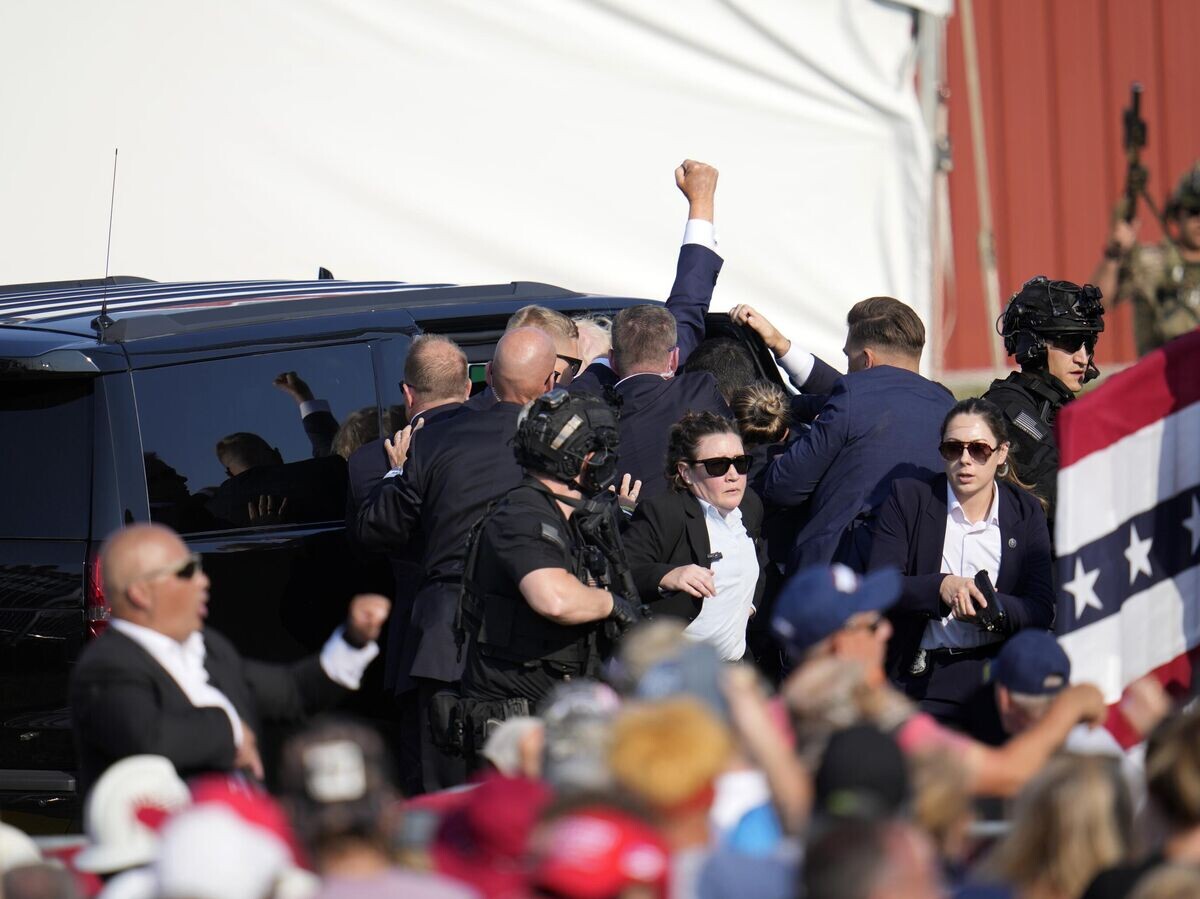    Дональда Трампа уводят в машину после стрельбы на митинге© AP Photo / Gene J. Puskar