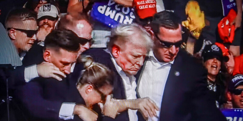 Трамп под охраной уходит с трибуны.  фото: картинки  яндекса.