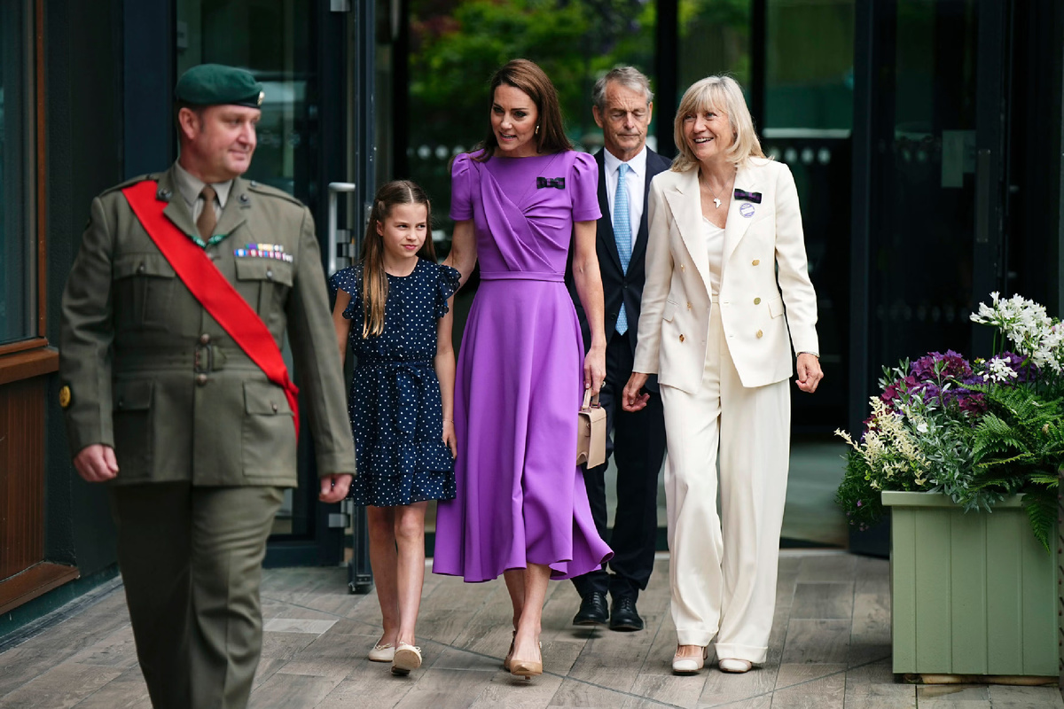 На принцессе Уэльской было ярко-фиолетовое платье с короткими рукавами от бренда Safiyaa, туфли-лодочки Camilla Elphick и кожаная сумка LK Bennett. На Шарлотте - синее платье в горошек от Guess. Фотография из открытого источника. 