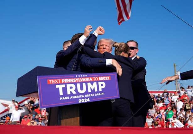 Трамп машет кулаком после получения ранения. Изображение из открытых источников