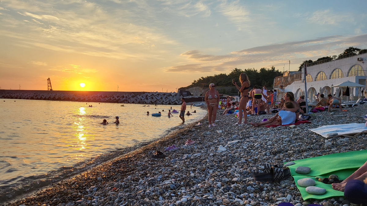 Пляж "Факел" на закате. Людей значительно меньше, чем в утренние и дневные часы.
