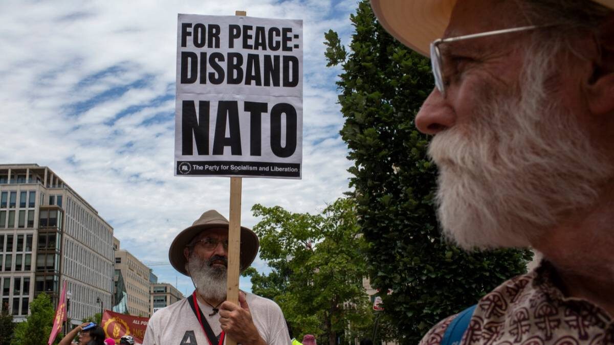    В преддверии саммита НАТО на митинге в Вашингтоне активист держит в руках плакат с надписью «За мир: распустить НАТО» / Фото: Zuma / ТАСС