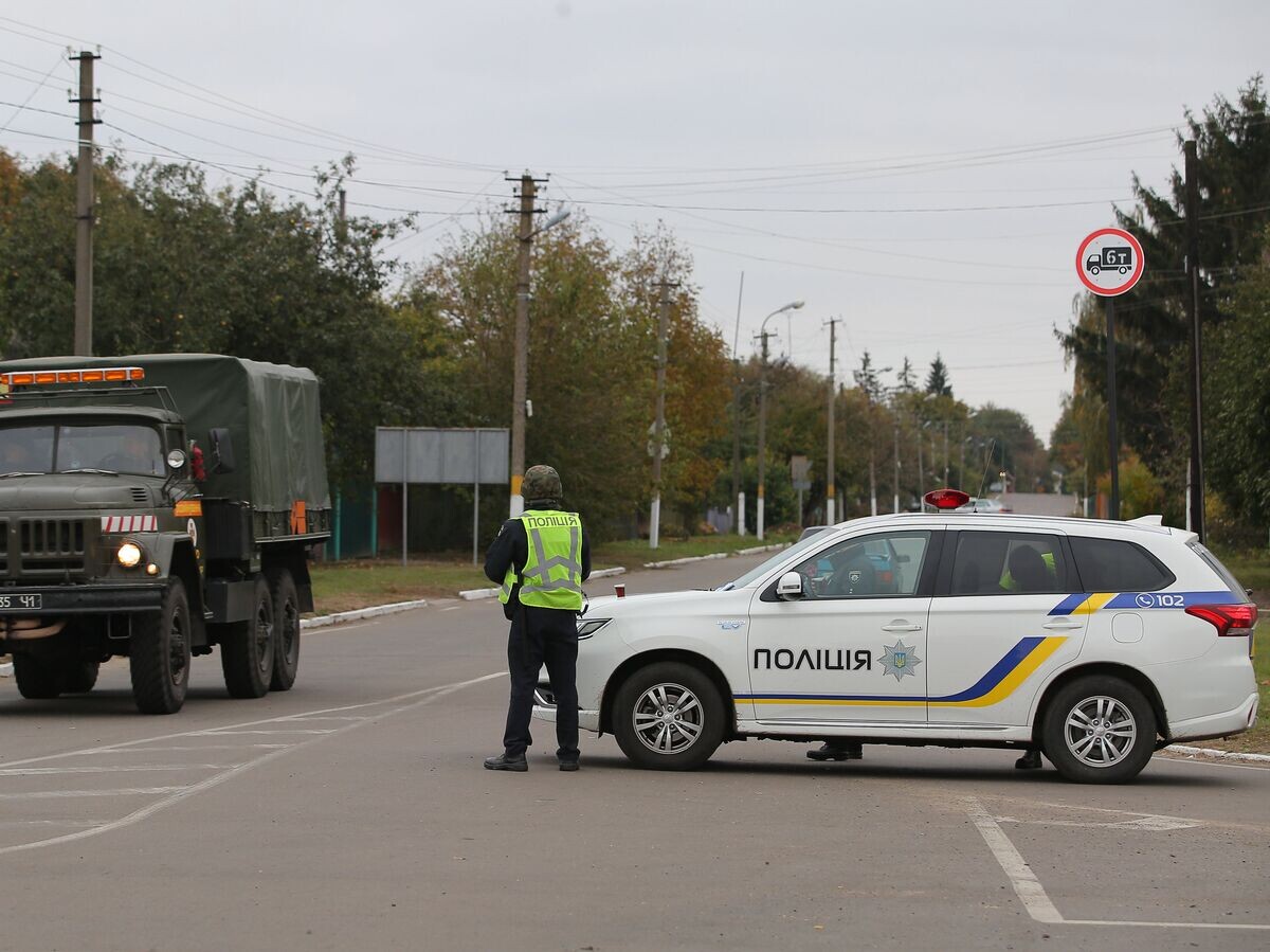    Сотрудники полиции Украины останавливают автомобили на дороге в Черниговской области после взрыва на военном складе. 9 октября 2018© РИА Новости / Стрингер