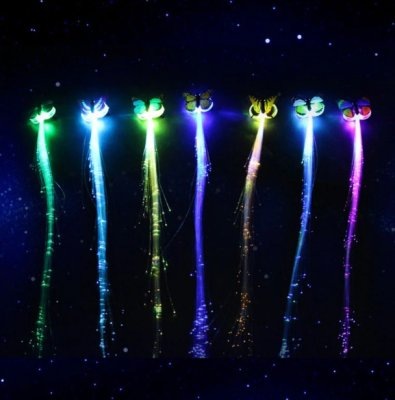 Яркий маникюр, броский макияж – этого не всегда достаточно, чтобы выглядеть по-настоящему ярко и необычно. Светодиодные волосы не только выделят из толпы, но и привлекут всеобщее внимание. Только ленивый не спросит, глядя на сверкающую светодиодными огнями прическу – как это устроено, и где можно такое купить. В комплект входит 10 светящихся прядей на прищепках в отдельных упаковках. Все они светятся разными цветами. Чтобы купить волосы конкретного цвета, придется написать продавцу с АлиЭкспресс, иначе он отправит то, что посчитает нужным. 
Крепятся необычные волосы с помощью прищепок, питаются от батареек, которые идут в комплекте. Важно обращать внимание на описание. Подсветка бывает разной – есть светодиоды с мягким мерцанием, а есть те, которые меняют цвета. Мигающие волосы больше подходят для Хэллоуина или Новогоднего карнавала. Да и интерьер ими можно украсить. Для дискотеки или вечеринки лучшими будут мерцающие пряди. Вот только кнопки для их выбора нет. Придется писать продавцу о своих требованиях в комментариях к заказу.