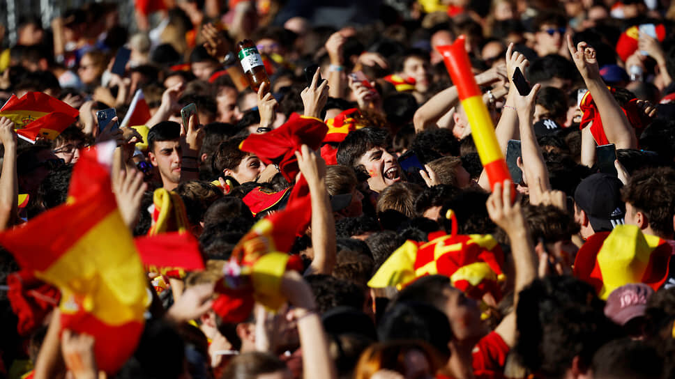    Десятки тысяч людей, одетые в красно-желтые цвета Испании, размахивают флагами Juan Medina/Reuters