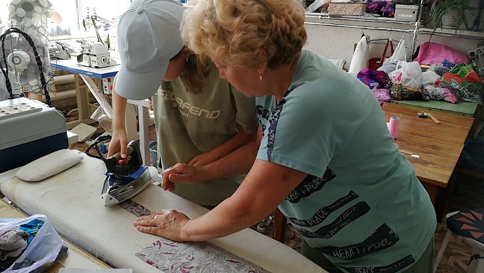 Девочка под руководством Вебелюнайте Ларисы Альгимантовны утюжит ткань