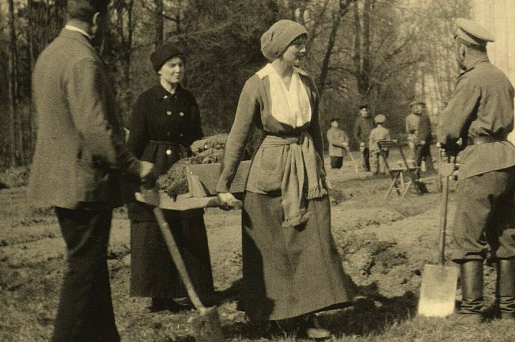 Императорская семья копает землю для огорода за Александровским дворцом, апрель 1917 года – княжна Татьяна несет носилки с землей, Николай II стоит с лопатой в руке. Позади Татьяны – фрейлина Анастасия Гендрикова.