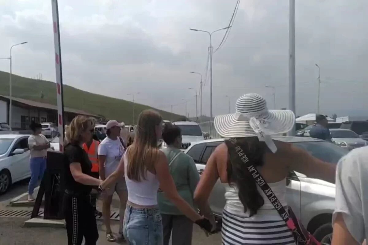    Кадр из видео: люди преграждают проезд автомобилям.