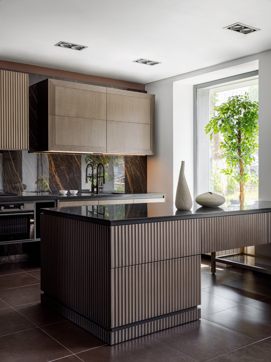 Остров и часть навесных шкафов обрамили поверхностями с имитацией волны. Такой вариант отделки может применяться для декоративных горизонтальных заглушек и ящичных фасадов либо для фасадов вертикальных заглушек и шкафов с выдвижными бутылочницами.