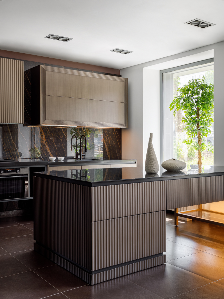 Остров и часть навесных шкафов обрамили поверхностями с имитацией волны. Такой вариант отделки может применяться для декоративных горизонтальных заглушек и ящичных фасадов либо для фасадов вертикальных заглушек и шкафов с выдвижными бутылочницами.