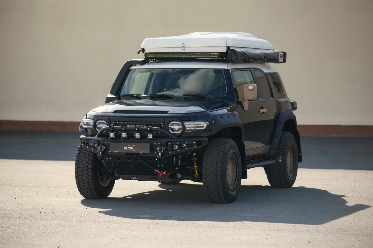 Тойота FJ Cruiser с тюнингом головного света, доп оптикой на дуге бампера, туманками в бампере и люстрой на багажнике