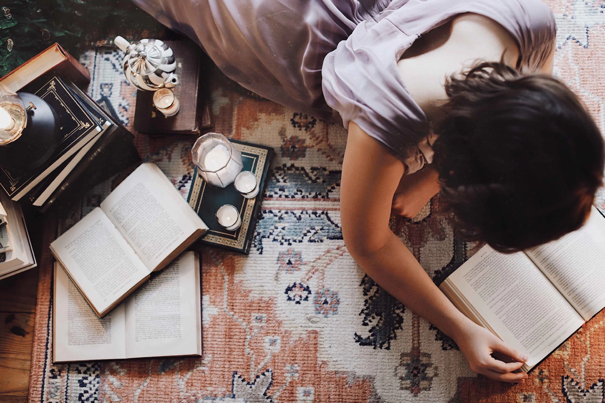 Фото https://unsplash.com/photos/woman-in-white-t-shirt-lying-on-floor-with-books-and-photos-vTsgVf6MF3U