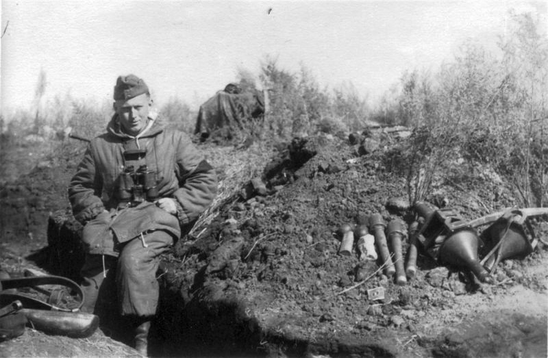 Фельдфебель 14-й роты 88-го гренадерского полка Траушель (Trauschel) на краю окопа в районе Северский Донец. На бруствере лежат гранаты и противотанковые мины кумулятивного действия Hafthohlladung 3 (Haft—H3, HHL 3).