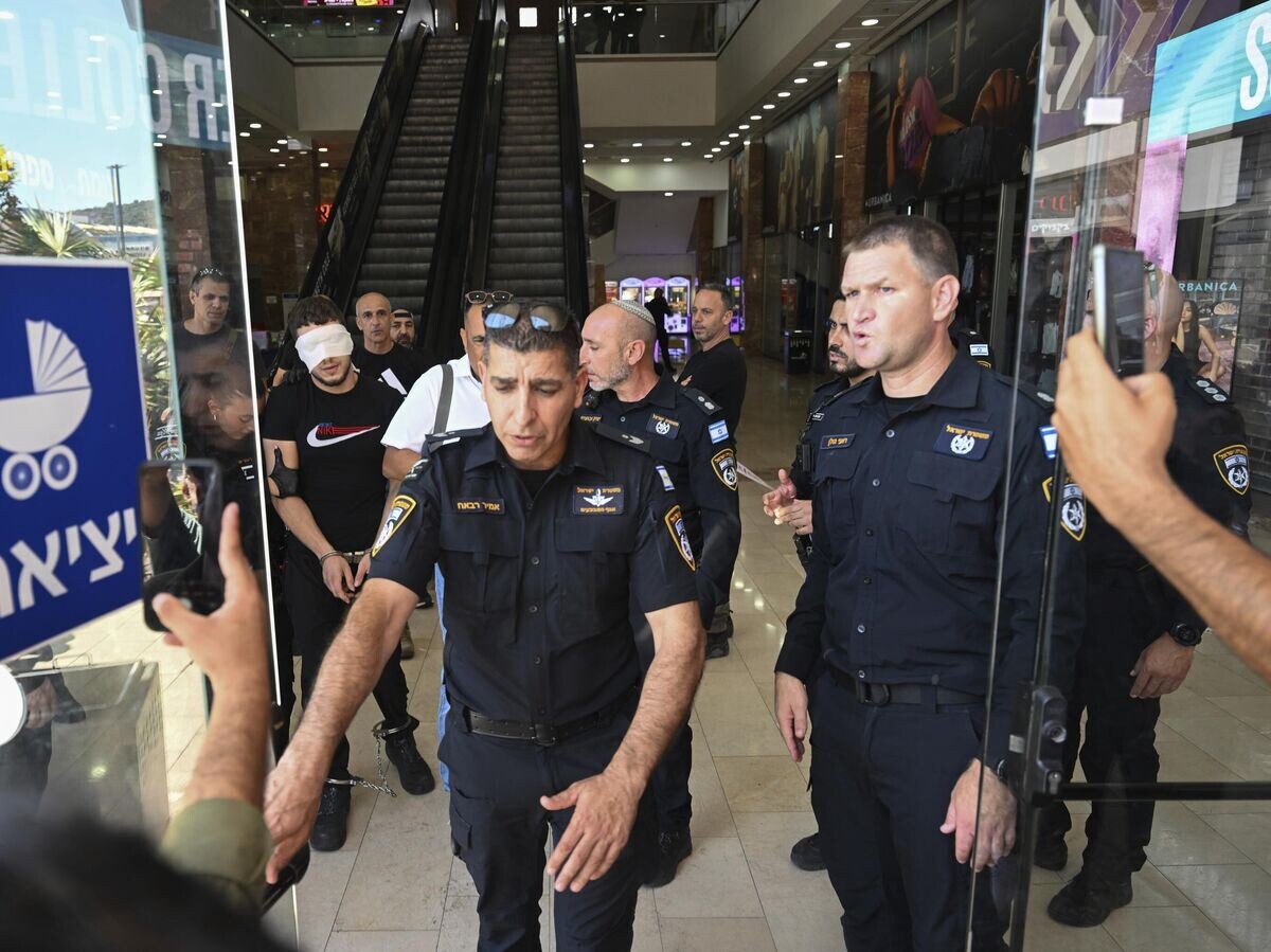    Израильская полиция арестовывает мужчину после теракта с ножом в торговом центре в городе Кармиэль на севере Израиля© AP Photo / Rami Shlush