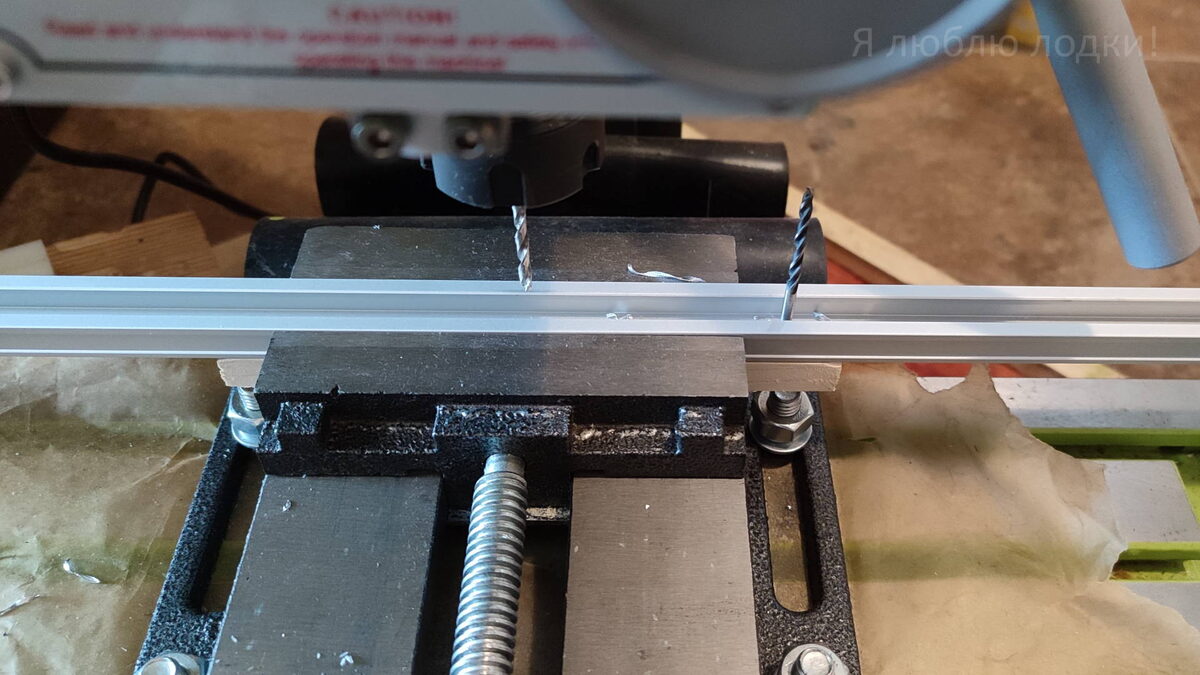 Кондуктор из деревянного бруска шириной 19.5 мм. Алюминиевый профиль шириной 19 мм свободно скользит между губками тисков. Просверленное отверстие является опорной точкой для следующего отверстия (галерея фото)