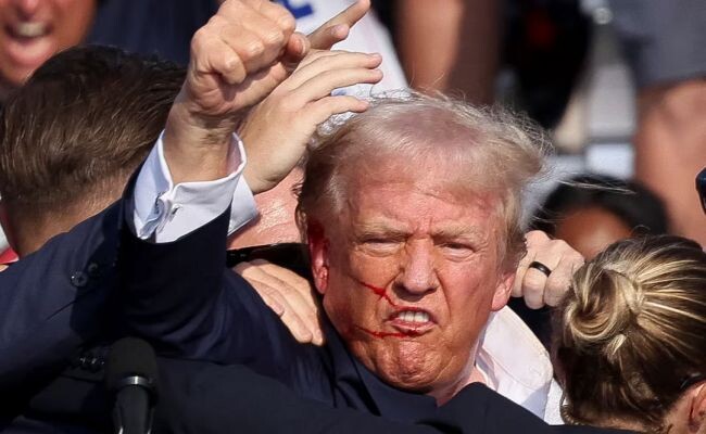 Трамп с ранненым ухом буквально через 5 секунд после промаха стрелка.