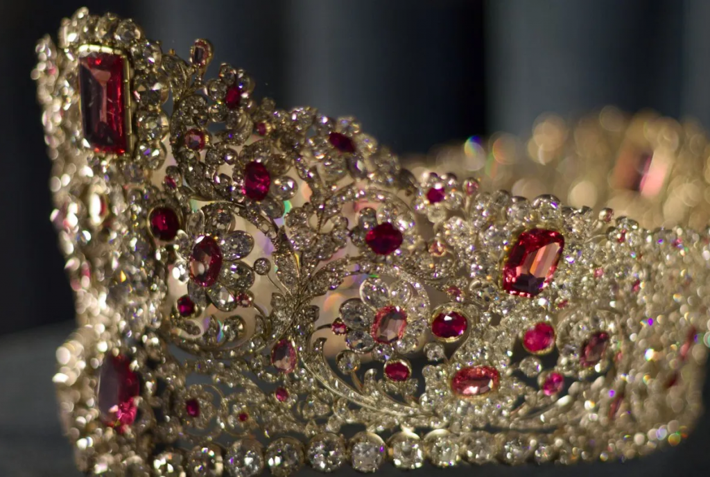 Узор на тиаре выполнены в виде цветов. Драгоценность сделана из золота и украшена бриллиантами, рубинами и шпинелями. 