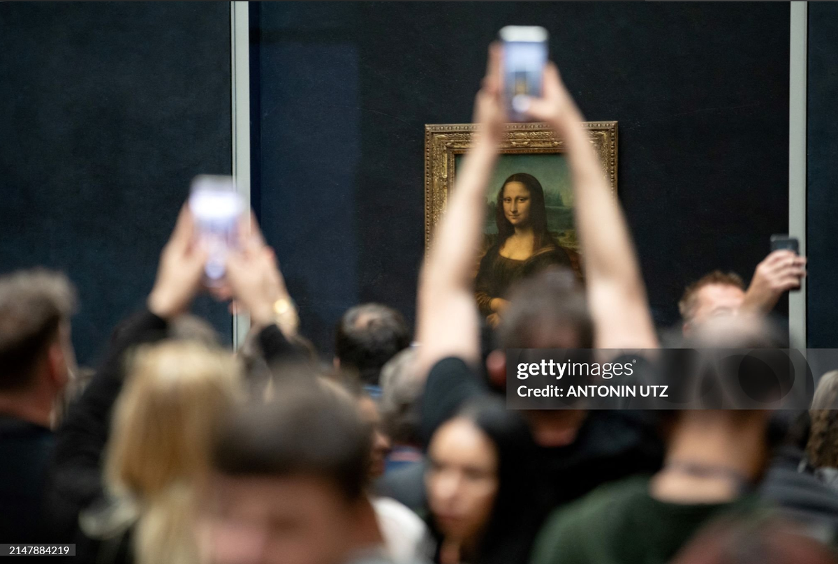 Посетители фотографируют картину Леонардо да Винчи «Мона Лиза» (Джоконда) в Лувре в Париже, 17 апреля 2024 года. (Фото Антонина УТЦ / AFP) (Фото АНТОНИНА УТЦ/AFP через Getty Images)