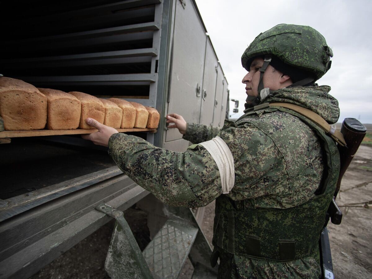    Военнослужащий ВС РФ грузит поддоны с выпеченным в мобильной пекарне хлебом в Херсонской области© РИА Новости