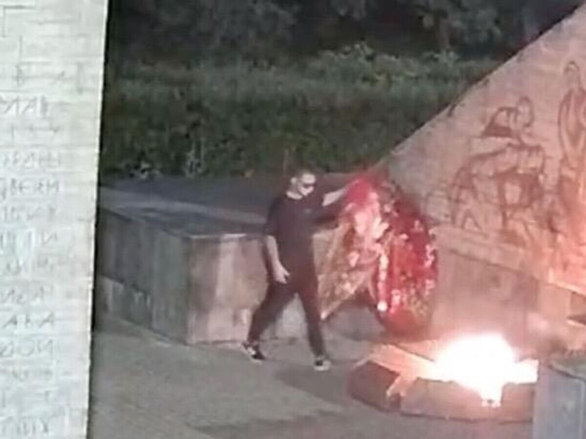    Житель Новгородской области бросает венки в пламя Вечного огня на мемориале в городе Старая Русса© СУ СК России по Новгородской области
