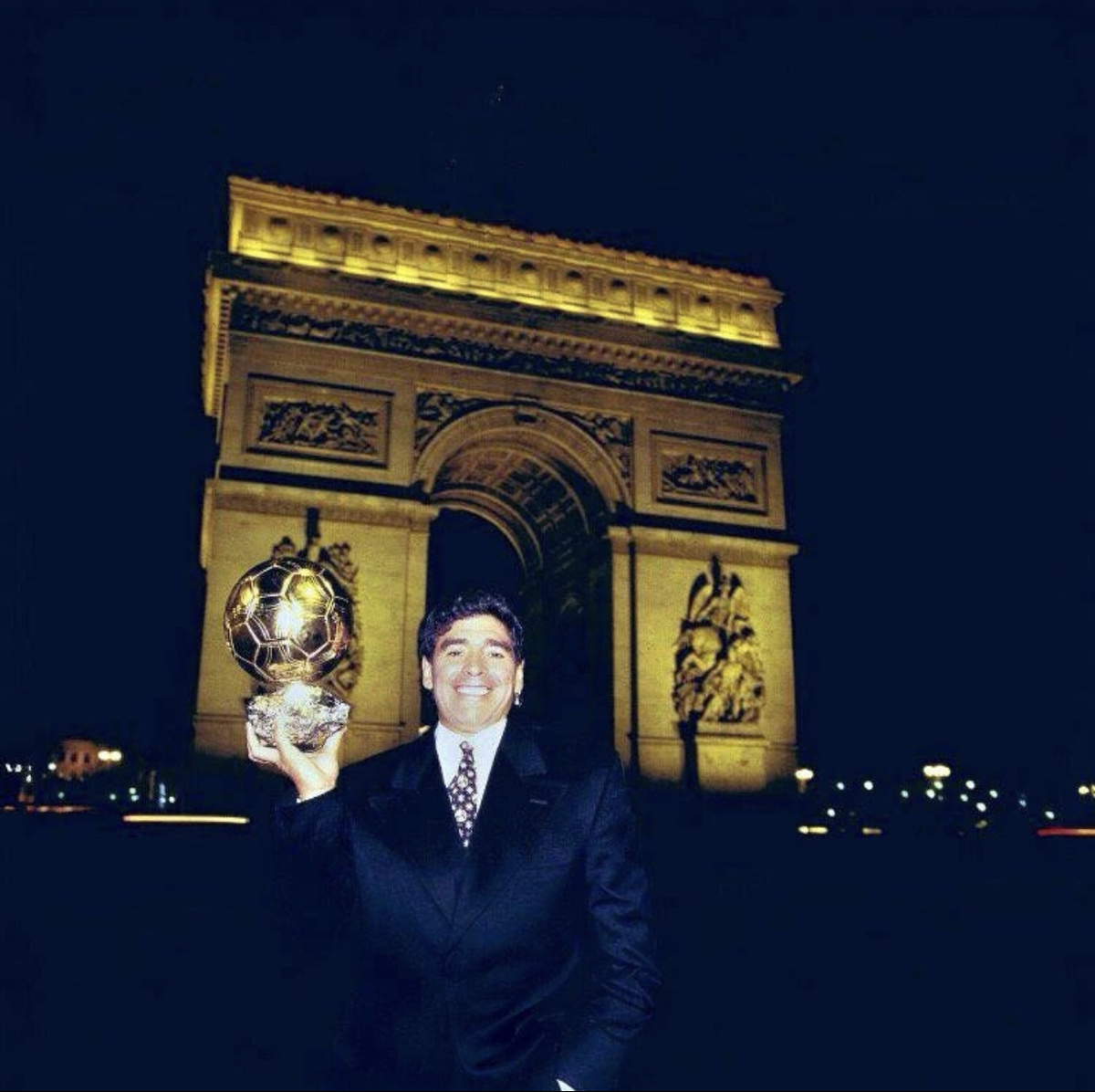 Диего Армандо Марадона с «Золотым мячом» на фоне Триумфальной арки в Париже. 1996 год.
