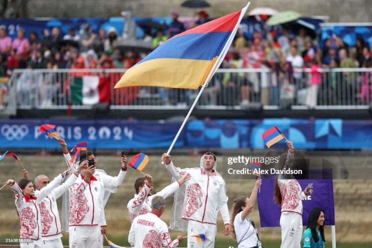    PARIS, FRANCE - JULY 26: Davit Chaloyan, Flagbearer of Team Armenia, waves the flag during the opening ceremony of the Olympic Games Paris 2024 on July 26, 2024 in Paris, France. (Photo by Alex Davidson/Getty Images) David Harutunov