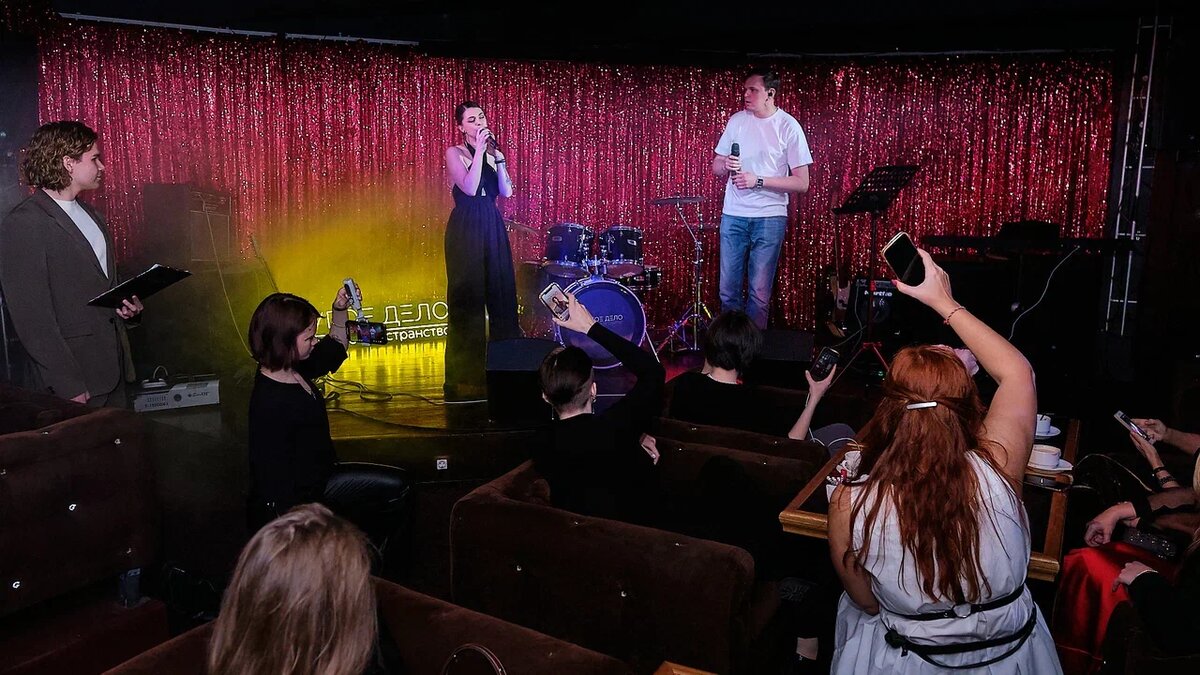 Музыкальная группа на сцене, выступает перед аудиторией. 