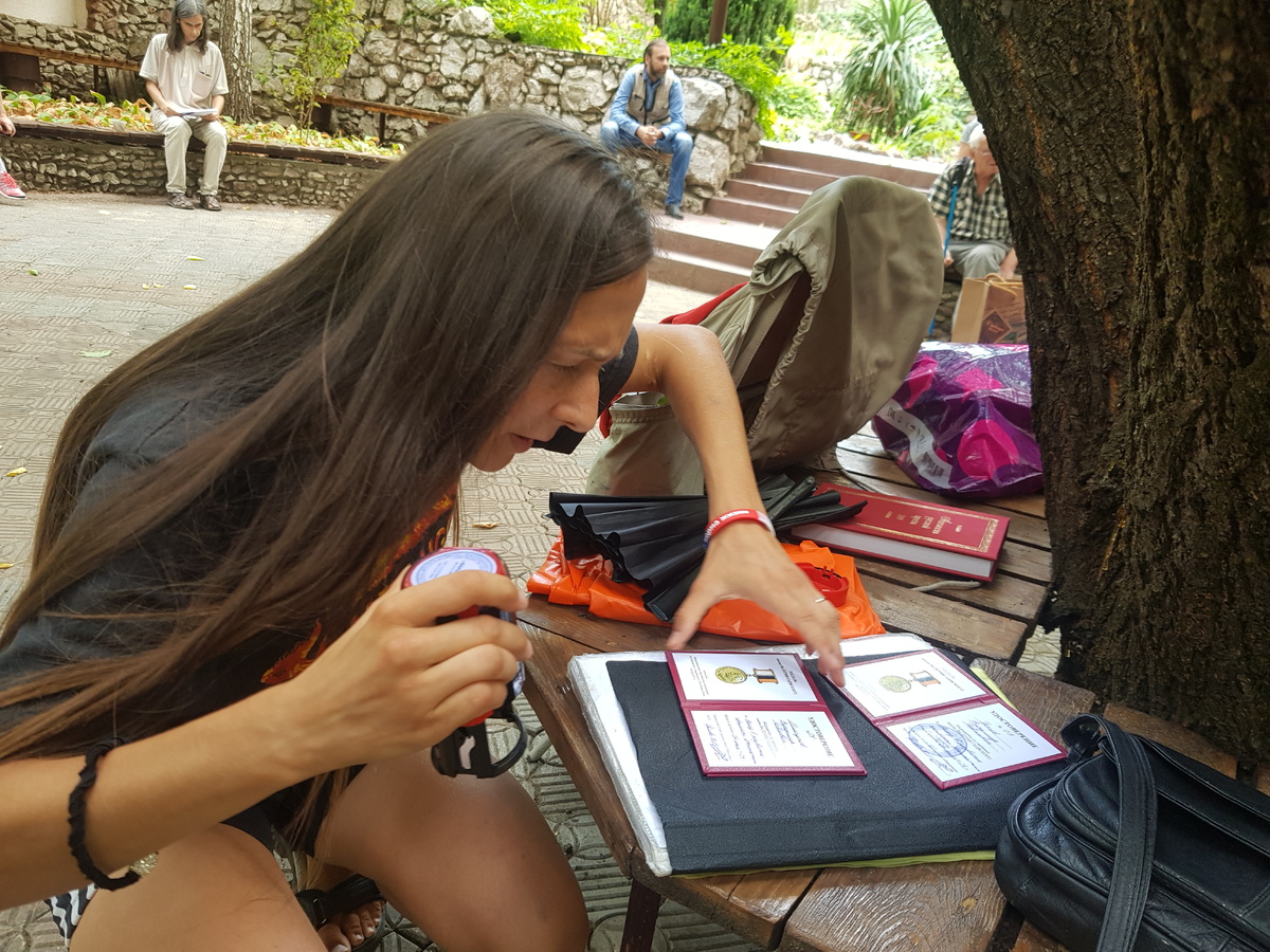 Юлиана Орлова ставит печати в удостоверениях к медали (с) Фото: Е. Горобцов