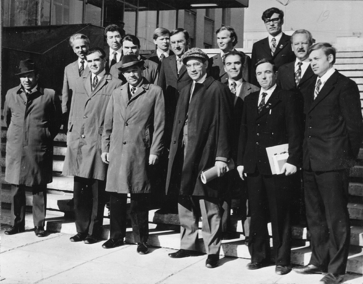 В первом ряду слева направо:1. Беляев Раис Киямович – первый секретарь горкома КПСС. 2. …3. Троицкий Михаил Трофимович – секретарь Татарского обкома КПСС. 4. Васильев Лев Борисович – генеральный директор КАМАЗа (1969-1981). 5. Барун Владимир Наумович – главный конструктор КАМАЗа (справа за спиной Васильева). 6. Саглаев Борис Павлович - секретарь партийной организации экпериментального цеха 7. Ядренцев Николай Васильевич - начальник отдела испытаний управления главного конструктора (далее - УГК). Во втором ряду слева направо: 1. Клепацкий Борис Трофимович – главный инженер КАМАЗа (1969-1975). 2. Родыгин Аркадий Андреевич – секретарь партийного комитета КАМАЗа (1971-1976).3. Остроушко Юрий Андреевич - начальник экспериментального цеха (далее - ЭЦ) УГК КАМАЗа.4. Колышкин ... - главный сварщик КАМАЗа. В третьем ряду слева направо: 1. Гилязов Ринат Риязович - председатель Набережночелнинского исполкома народных депутатов. 2. Жирнов ... - фрезеровщик ЭЦ УГК КАМАЗа. 3.  Кокорев Юрий - технолог экспериментального цеха. 4. Семёнов Анатолий Федорович - секретарь партийной организации УГК КАМАЗа.