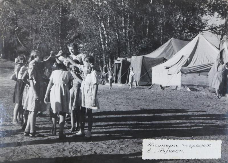  📷   Как в советские годы отдыхали дети строителей Сталинградской ГЭС">📷
Фото: фонд МБУ «Волжский музейно-выставочный комплекс»- Я работал в 1952 году начальником отдела кадров, а по вечерам, на общественных началах, как оперативный дежурный, находился в приёмной Ф. Г. Логинова. Дежурили втроем, по очереди. Принимали телефонные звонки. Какие вопросы могли решить сами – решали, а более сложные – записывали и к утру на стол начальнику строительства. Логинов в своем кабинете работал допоздна и просил его не беспокоить. Как-то он попросил принести ему чаю. За чашкой чая стал расспрашивать меня о моем образовании, где и кем работал. Узнав, что я окончил курсы старших пионервожатых, просил подумать о должности начальника пионерлагеря. Дальше мы этот вопрос решали с Вощенко, председателем постройкома. Он же оперативно подобрал коллектив (воспитатели, врач, кухонные работники, повара, завхоз), организовал доставку продуктов в пионерлагерь. Конечно, от этих дел и я не стоял в стороне. До лагеря добирались по железной дороге Сталинград-Себряково, потом машинами. Пионервожатых отбирали райкомом Михайловки из местных жителей.С благодарностью вспоминаю повара, ее разнообразное, продуманное меню. Ее требования к поставляемым продуктам как по качеству, так и по набору соблюдались неукоснительно, строгая была. Для меня самым ответственным моментом было купание детей в реке Медведице – быстрая, опасная река. Детей так и тянуло к ней. Примерно 100 человек, четыре отряда, весь день бы в ней купались. Но много было и других интересных дел: спортивные состязания, игры, пионерские костры, концерты. Просто здорово проходили концерты «на выезде», например, в Дубовке.📷
Фото: фонд МБУ «Волжский музейно-выставочный комплекс»-  А дети из Дубовского пионерлагеря выступали с ответным концертом на нашей сцене. И тоже успешно. Готовились к приезду родителей. Каждое воскресенье – праздник для детей и родителей. Столовская еда на столах, покрытых белыми скатертями, поглощалась с одобрением.А как торжественно проходил прием в пионеры! Проходил на торжественной линейке, с выстроенной по отрядам дружиной и с поднятием флага лагеря. Старшая пионервожатая произносила напутствие, повязывался галстук. Ребенок отдавал салют и на ее (пионервожатой) «Будь готов!» отвечал «Всегда готов!».Детям запомнился организацией игры «Поиск клада». Даже вожатые не знали, где он спрятан. В этот день участвовали все отряды. По указанному маршруту, с выполнением заданий они шли к одной цели. Разведчики от отрядов находили записки с заданиями. Отряд, пришедший первым, был награжден необыкновенно вкусным, огромным караваем (плод труда нашего повара). Разведчику отряда-победителя вручили коробку конфет. А что же представлял из себя клад? Это были... запрятанные столовые приборы.Я договорился с воинской частью, дислоцировавшейся рядом, о предоставлении полевой кухни нашим поварам. Так что вкусный обед был замечательным завершением похода, а найденный клад – столовые ложки – как нельзя пришлись к месту. Добавлю еще одну деталь. Работая в пионерлагере, я не думал о своем доме, так как жена Наталья работала воспитателем, а сынок Юра находился в одном из отрядов – тоже на глазах,- воспоминания волжанина.📷
Фото: фонд МБУ «Волжский музейно-выставочный комплекс»Напомним, что много лет назад близ Волжского находился знаменитый не только во всем регионе, но и по стране пионерский лагерь «Артек на Ахтубе». Сюда приезжали дети со всего Советского Союза, но в нашем столетии его забросили. Сегодня на месте бывшего лагеря не найти даже руин – территорию распродали под дома и коттеджи.Светлана Джигарос