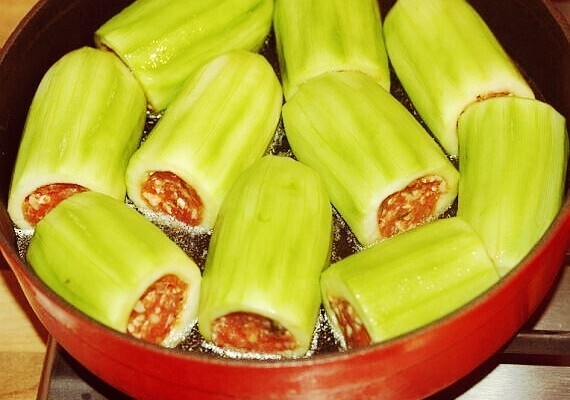 Ингредиенты:                                                                                                                                             Для кабачков: Кабачки - 10–12 штук.         Бульон куриный ) - 500 милилитра. Для начинки: Фарш говяжий  - 450 грамм.     Лук репчатый - 1 штука.      Морковь - 1 штука.      Помидор консервированный (в собственном соку) - 1 штука. Сок из под консервированных помидор — 3 столовые ложки. Рис круглозерный 50 грамм.      Укроп свежий - 1 пучок.      Петрушка свежая - 1/4 пучка. Масло растительное - 3 столовые ложки. Соль - по вкусу. Перец черный молотый - по вкусу.              Для лимонного соуса:              Яйца - 2 штуки. Желток яичный - 2 штуки.        Мука пшеничная - 2 столовые ложки. Сок лимонный - 4 столовые ложки. Укроп - 4 веточки.         Соль - по вкусу. Перец черный молотый - по вкусу .                                                                   Приготовление:                                                                                                                                  Сперва кабачки нужно промыть и срезать верхушку, а затем вырезать сердцевину.    Затем возьмите овощечистку и пройдитесь по стенкам кабачков изнутри, удаляя мякоть.              И в самом конце снимите с овощей кожуру.                Очистите лук и морковь.    Морковь натрите, а лук мелко нарежьте. Обжарьте затем эти овощи в растительном масле до мягкости, то есть, примерно, в течение 10 минут.    Добавьте к луку с морковью измельченный консервированный помидор, вместе с томатным соком. Перемешайте и тушите все вместе еще 5 минут.         Теперь в сковородку идет рис.             Готовьте еще около 3 минут.     В самом конце добавьте к овощам свежую зелень и хорошо перемешайте. Снимите с огня. Смешайте овощи и рис с говяжьим фаршем, солью и перцем, добавьте около 1/4 стакана холодной воды и смешайте все вместе.   Масса не должна быть густой, напротив, мягкой и чуть водянистой. Заполняйте кабачки фаршем неплотно, так как рис в процессе разбухнет, оставьте для него место.         Теперь переложите фаршированные кабачки в форму для запекания так, чтобы овощи лежали в один слой.          Залейте все куриным бульоном  и посолите сверху. Поставьте духовку разогреваться до 180С.                 В это же время поставьте форму с кабачками на огонь и доведите до кипения.     Затем накройте крышкой или фольгой и отправьте в духовку.    Запекать фаршированные кабачки нужно в течение 50-55 минут.               И обязательно возьмите на пробу немного начинки, чтобы убедиться, что рис проварился и все готово. Готовые фаршированные кабачки переложите в тарелку и накройте фольгой, чтобы они не успели быстро остыть. Оставшийся в форме для запекания бульон перелейте в мерную чашу. Нам нужно 400 мллилитра. Лимонный соус:   В кастрюле взбейте яйца с желтками и лимонным соком. Добавьте затем муку и вновь все очень хорошо перемешайте венчиком.       Когда все комки будут разбиты, продолжая мешать, влейте в яичную смесь горячий бульон из-под кабачков. Взбив хорошо все вместе, поставьте соус на очень медленный огонь (массе ни в коем случае нельзя давать кипеть!) и готовьте все, взбивая венчиком, пока не загустеет.        По времени это займет около 5 минут.       Снимите кастрюлю с лимонным соусом с огня, добавьте соль, перец и бросьте мелко нарубленную зелень.      Подавать блюдо нужно сразу после приготовления. Полейте соус сверху на овощи с мясом и подавайте ваши фаршированные кабачки по-гречески к столу горячими!        Это очень вкусно, настолько, что и на праздничном столе будет очень даже к месту.                                                                          Приятного аппетита! Подписывайтесь на мой канал!