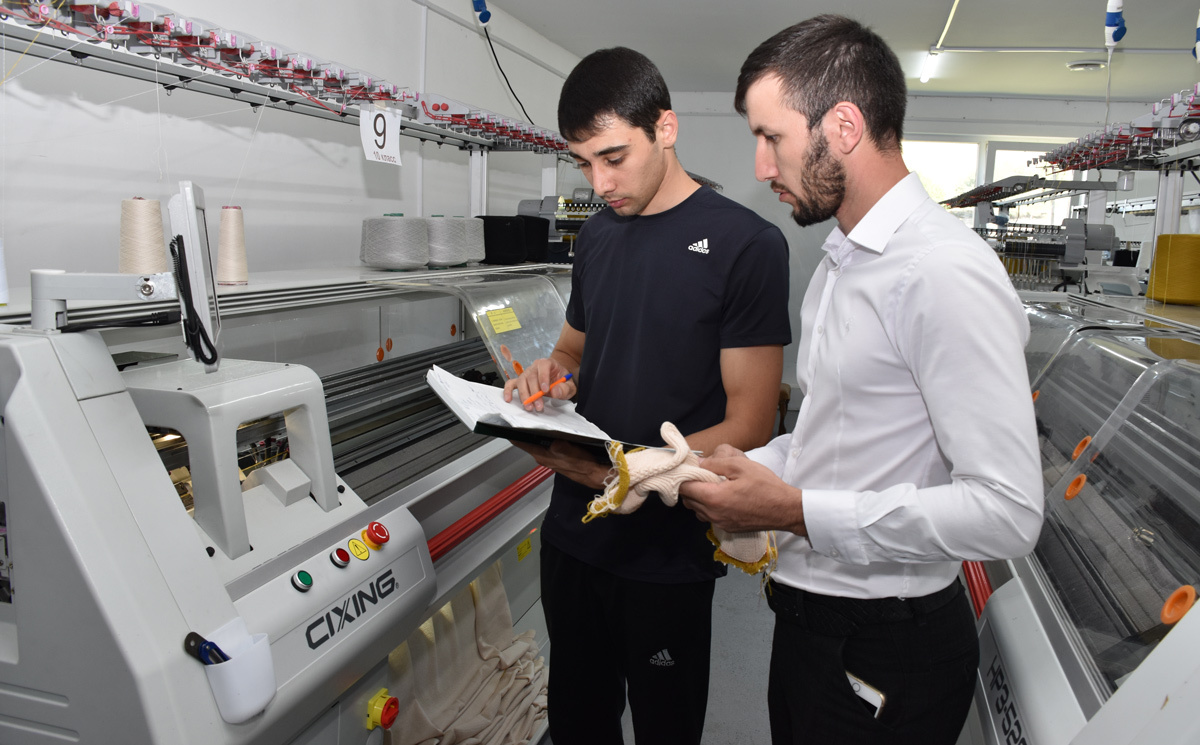 Казбек Канаматов (справа) и оператор плосковязальной машинки Динислам Джубуев. Фото Светланы ОСЕЦКОЙ.