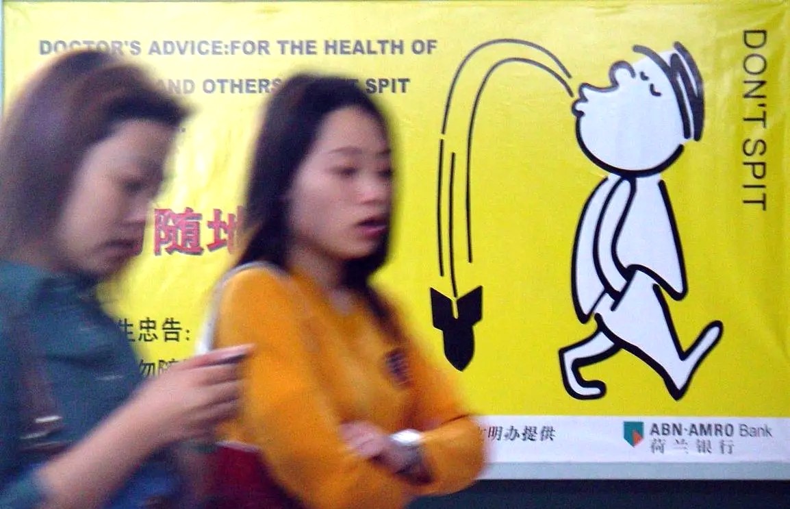 Баннер на улицах Китая, надпись здесь предупреждает людей о том, что не нужно харкать на улице куда попало.