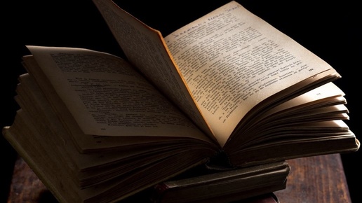 старая книга с закладкой на тёмном столе