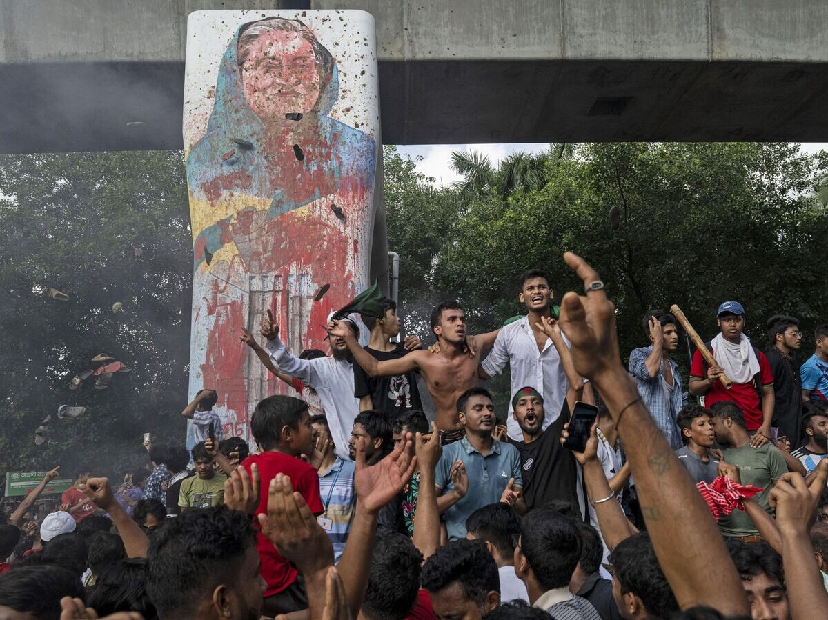    Протестующие у мурала с портретом Шейх Хасины в Дакке© AP Photo / Fatima Tuj Johora