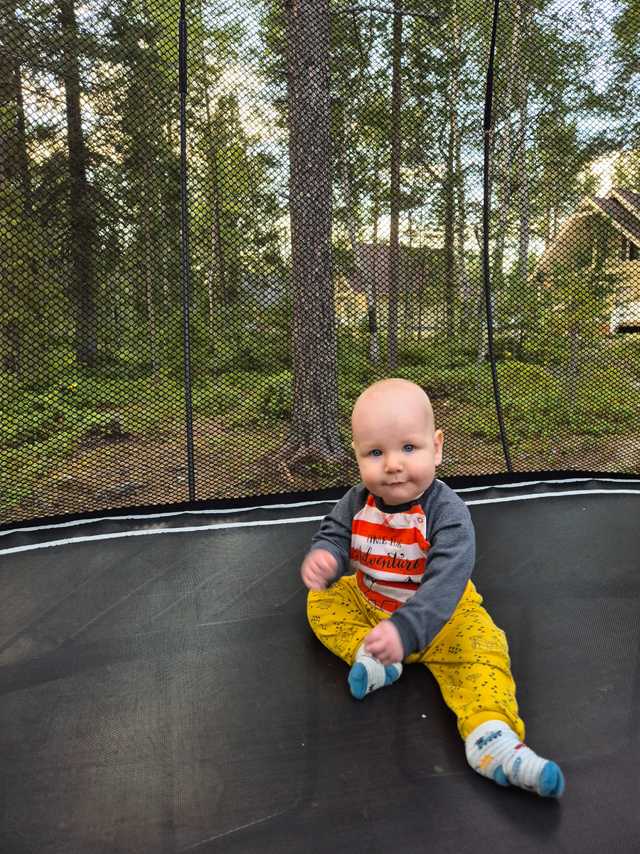 Коля сидит на батуте и размахивает руками