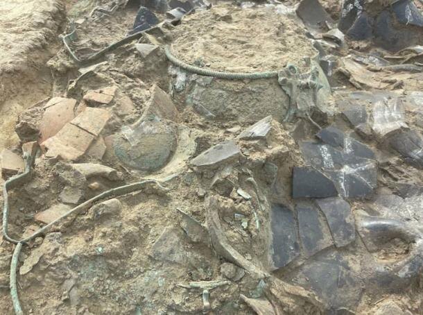 Бронзовый котел, среди многих других бронзовых предметов в захоронении. 