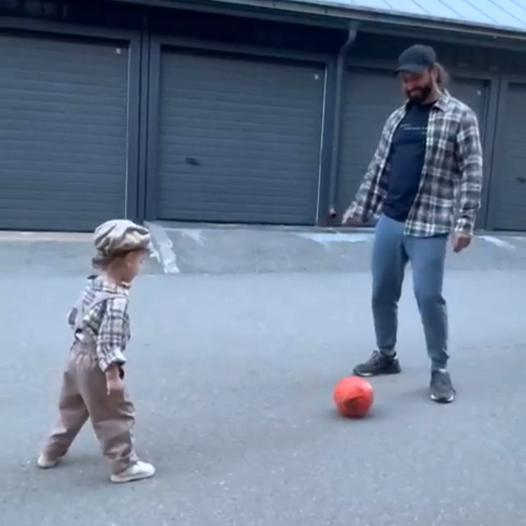 Папа и сын играют в футбол