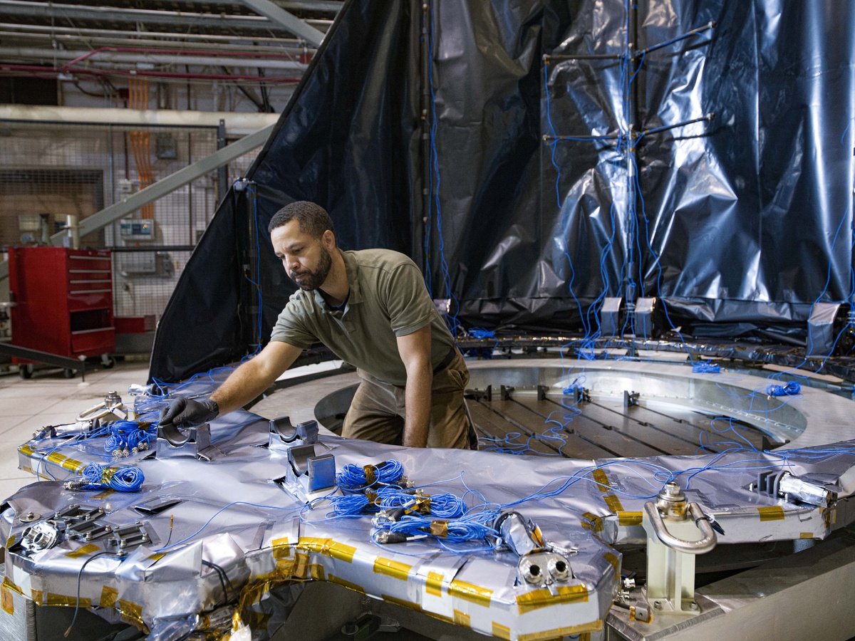 Брайан Симпсон, руководитель отдела в Центре космических полётов имени Годдарда NASA, настраивает датчики на развёртываемой крышке апертуры для космического телескопа Nancy Grace Roman. Датчики собирали данные о реакции DAC на испытания.    
 Источник: NASA / Chris Gunn  📷
