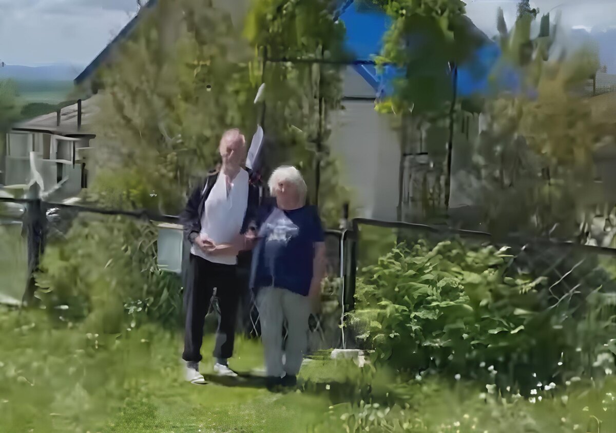 Скрин видео. Флаг виднеется между парой на заднем фоне