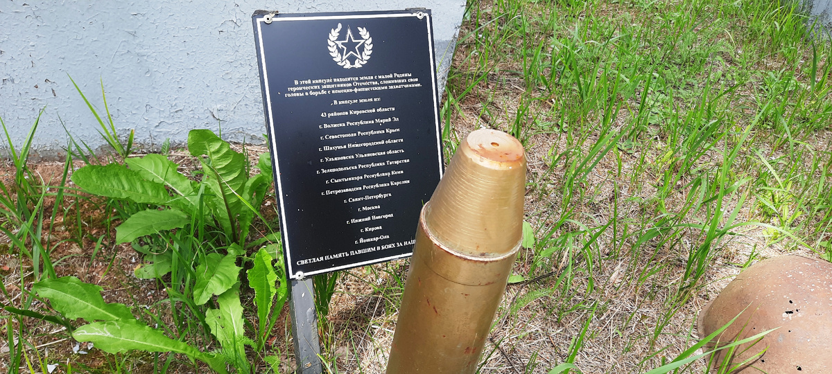Текст на табличке: "В этой капсуле находится земля с малой Родины героических защитников Отечества, сложивших свои головы в борьбе с немецко-фашистскими захватчиками". 
Перечислены 12 мест и городов и 43 района Кировской области.