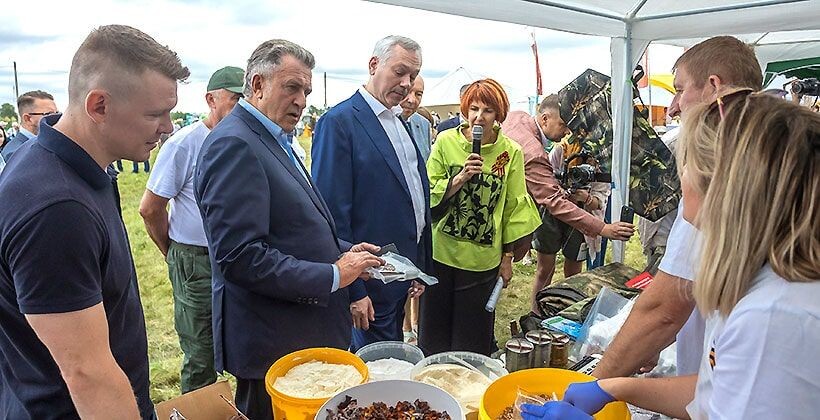 Андрей Шимкив и Андрей Травников (в центре) знакомятся с выставкой на Дне поля. 
