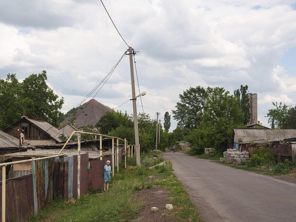    Женщина смотрит на улицу из своего дома во время эвакуации в городе Дзержинск (Торецк)© AP Photo / Evgeniy Maloletka