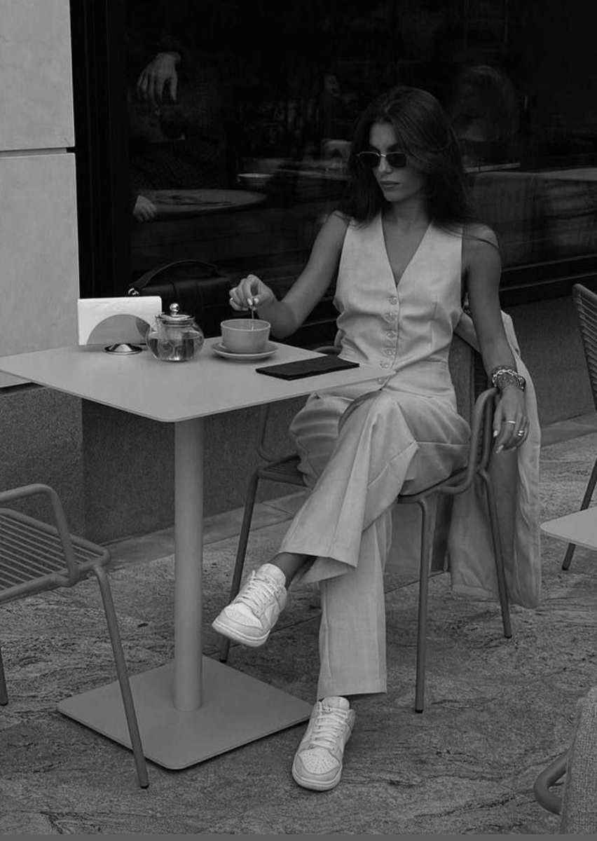 В данном случае девушка выбрала монохромный образ в светлых оттенках, который подчеркивает её утончённость и изысканность. Белые кеды добавляют луку немного расслабленности, что делает его идеальным как для деловой встречи, так и для утреннего кофе в модном кафе. Этот образ вдохновляет на то, чтобы экспериментировать с разными фактурами и оттенками одного цвета, создавая глубину и интерес, даже в рамках минимализма.