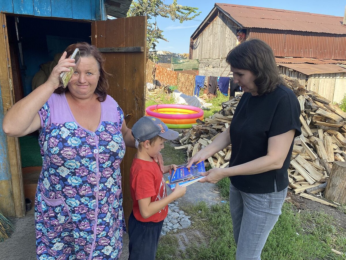 Заречнева Лариса Павловна передаёт мальчику тетради