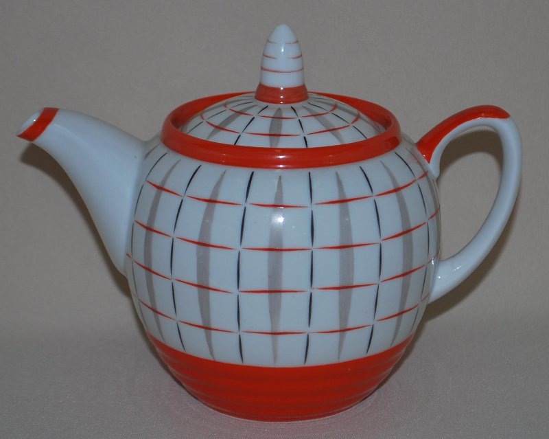 Чайник с крышкой из сервиза "Клеточка". 1958. Автор формы "Кольцами" Ганрио Ю.Б., автор росписи "Клеточка" Смирнов Е.П. Федеральное государственное бюджетное учреждение культуры "Сергиево-Посадский государственный историко-художественный музей-заповедник". Листайте галерею вправо.