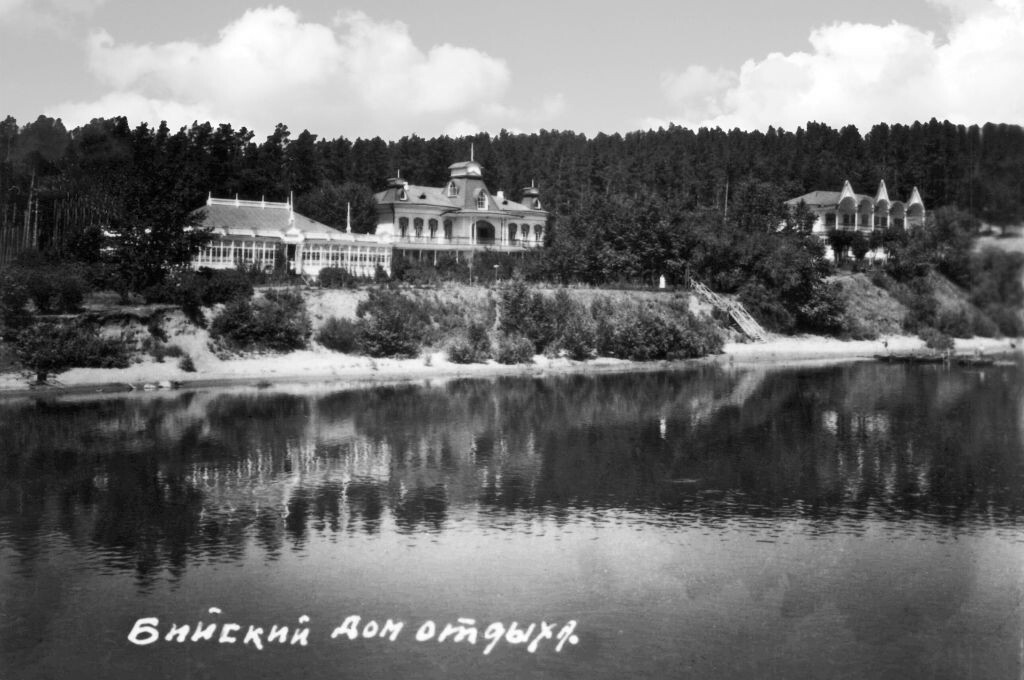     Середина 1950-х годов. Вид с песчаного островка в 20-30 метрах от противоположного берега. Слева – столовая, в центре – корпус №1, справа – корпус №2. Видна лестница, ведущая к реке, справа от нее виден причал лодочной станции. .архив